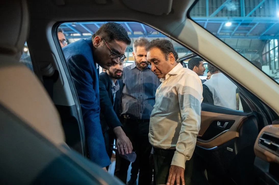 A group of men standing in a car

Description automatically generated