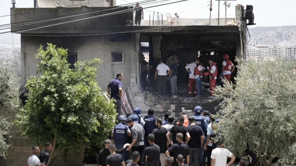 Palestinian first responders work in the rubble of a home destroyed in an Isareli strike in the West Bank city of Jenin on Friday. 