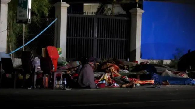 People covered in duvets and throws sleep on a roadside after an earthquake in Nay Pyi Taw