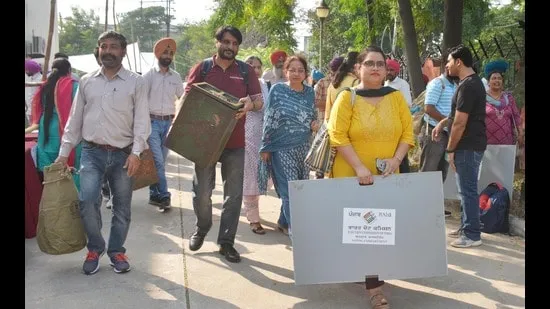 সোমবার অমৃতসরে গ্রাম পঞ্চায়েত নির্বাচনের প্রাক্কালে ভোটগ্রহণ কর্মকর্তারা তাদের নিজ নিজ ভোটকেন্দ্রে যাওয়ার আগে ভোটদানের উপকরণ বহন করছেন। (সমীর সেহগাল/হিন্দুস্তান টাইমস)