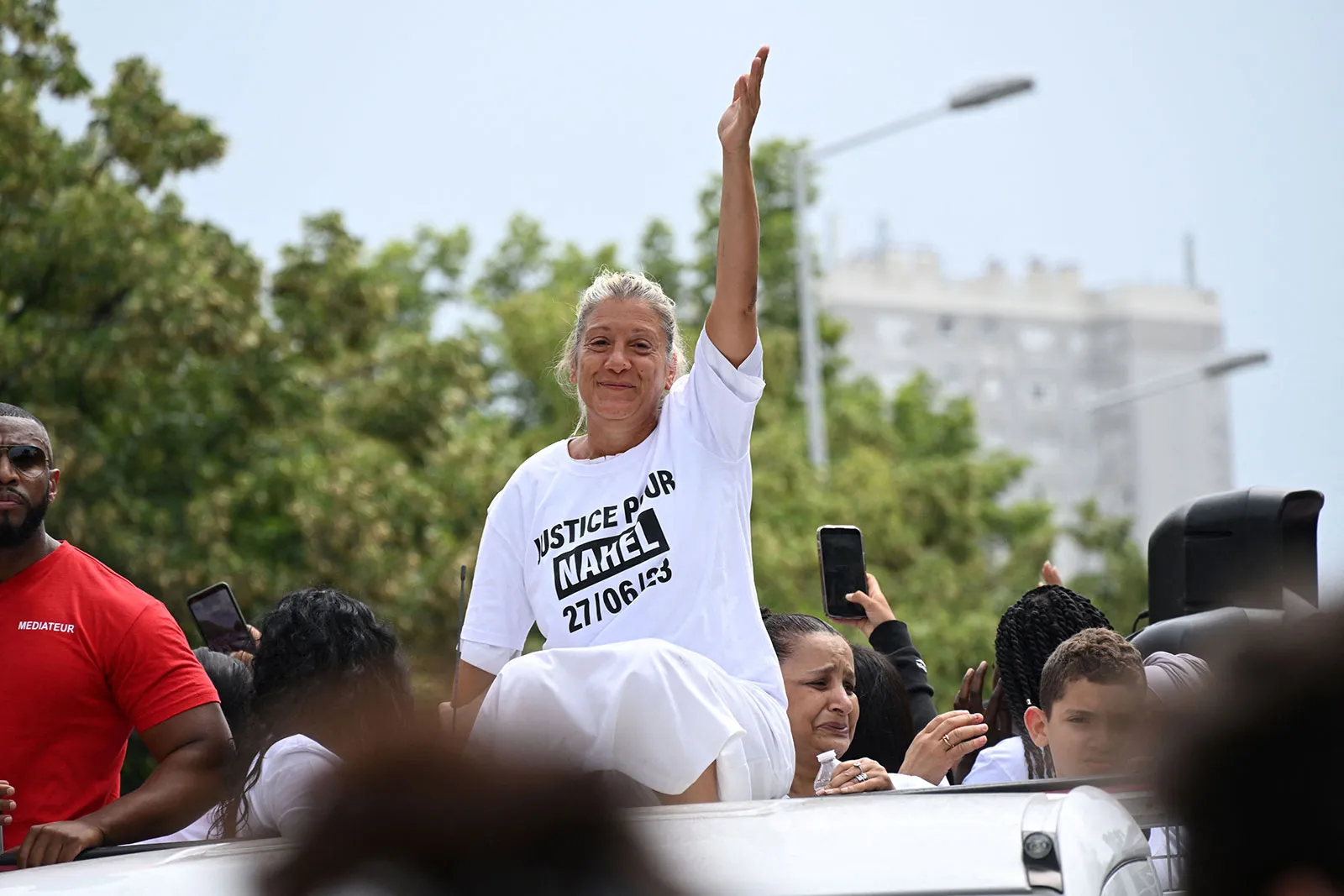 Mounia, identified by CNN affiliate BFMTV, gestures as she sits atop a truck during a march for 17-year-old Naël in the Paris suburb of Nanterre on June 29. 