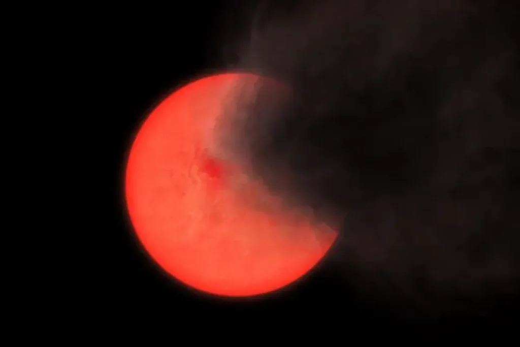 An artist's rendition depicting a cloud of smoke and dust ejected by a red giant star. Credit: Philip Lucas/ University of Hertfordshire<br />
