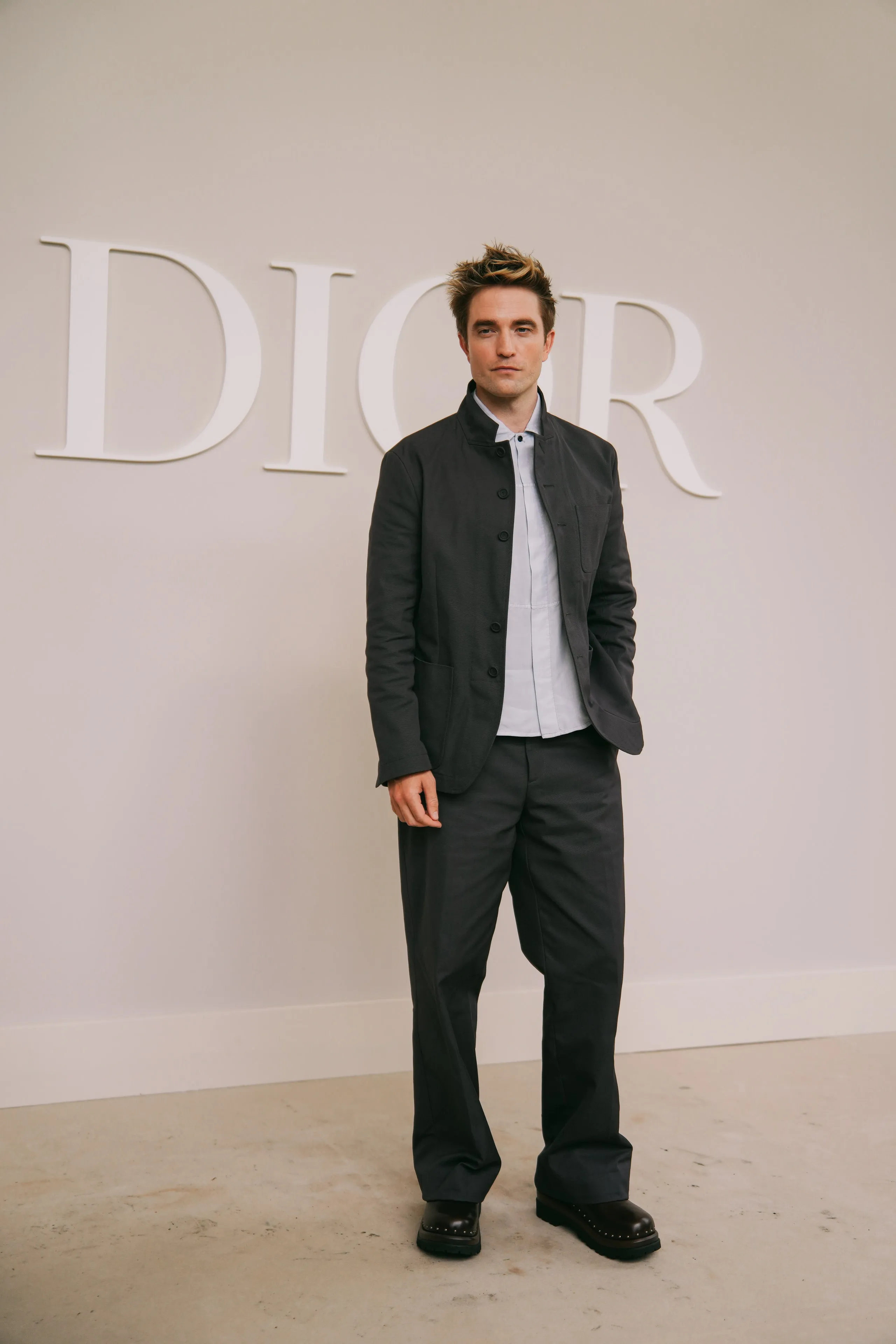 Image may contain Robert Pattinson Clothing Formal Wear Suit Blazer Coat Jacket Adult Person Standing and Tuxedo