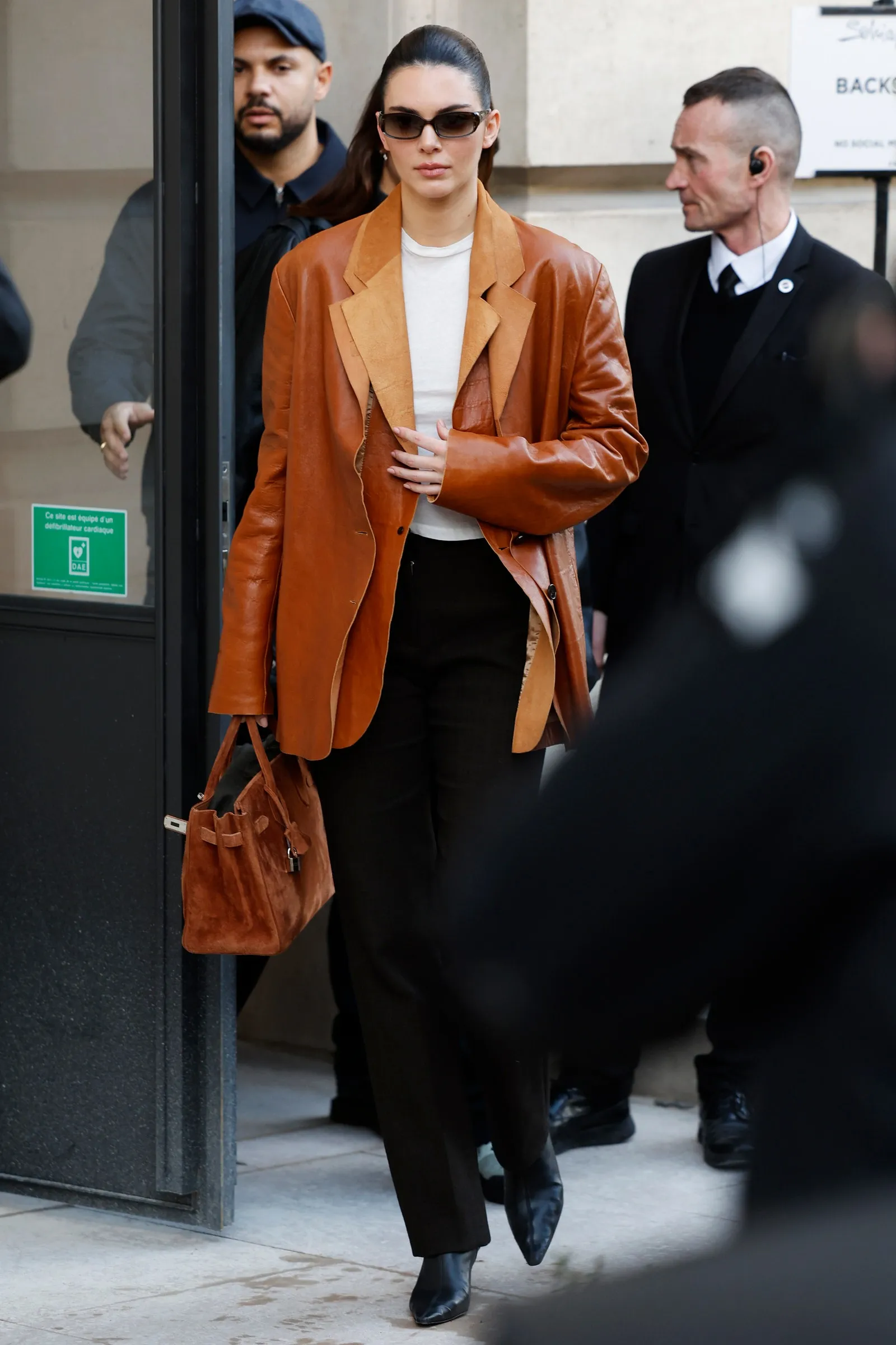 PARIS FRANCE  JANUARY 27 Kendall Jenner wears white top brown leather double blazer brown suede Hermès bag black...