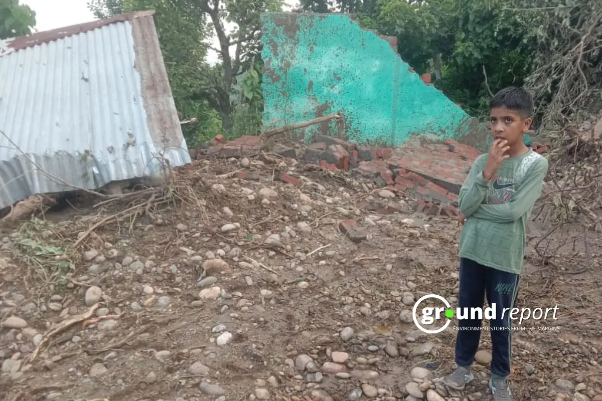 A young boy stands in front of the rubble of his home in Doonga village, Kathua district, after a cloudburst on August 6th.