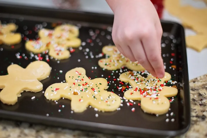 A hand decorates cookies