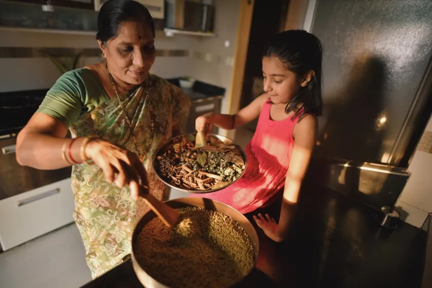A woman and a child cook in a kitchen
