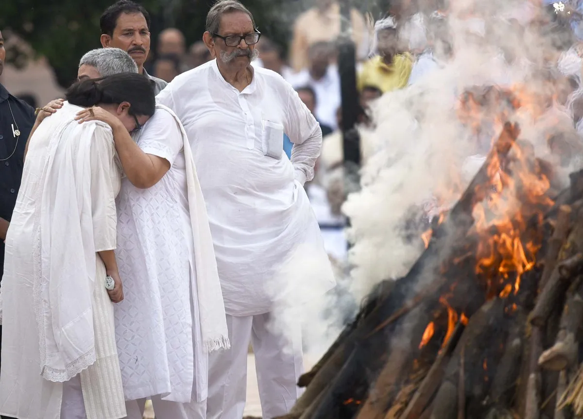 Namita Kaul, the adopted daughter of former Prime Minister of India Atal Bihari Vajpayee, lighting the mortal remains of Vajpayee.  (Photo: PTI)