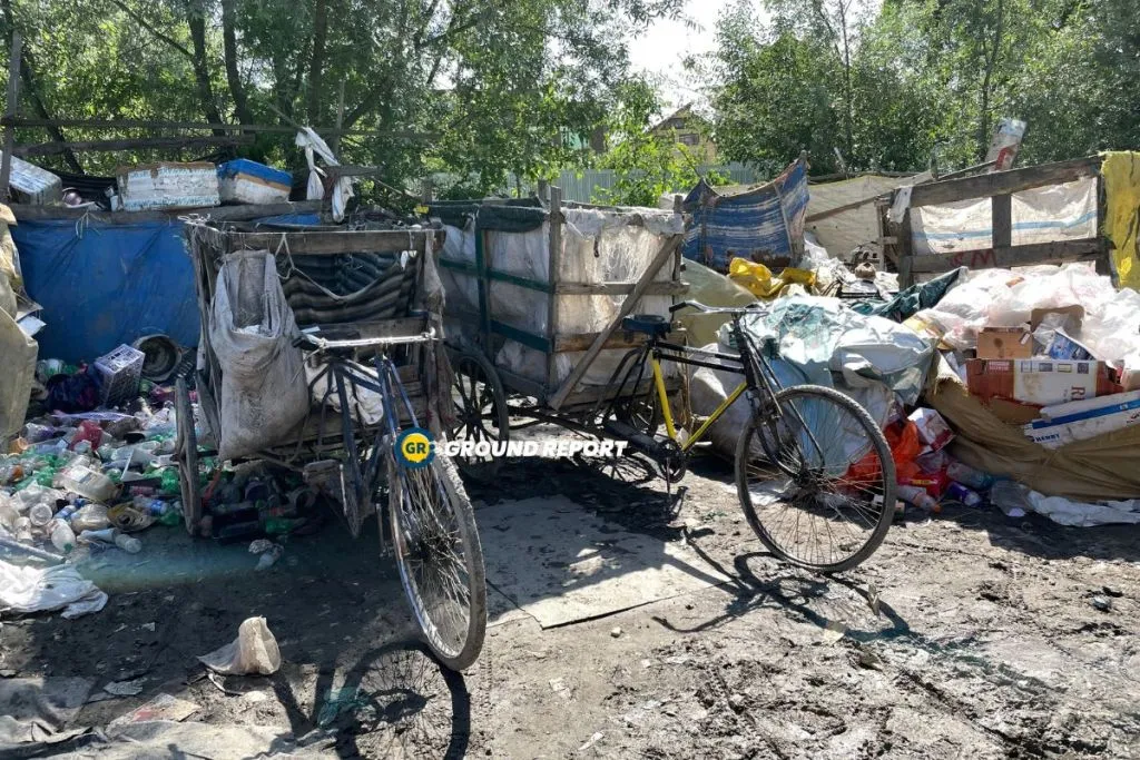 Amidst their collection of waste from various sites, rag pickers pause for casual conversation outside their huts.  Photo Credit: Seerat Bashir/Ground Report