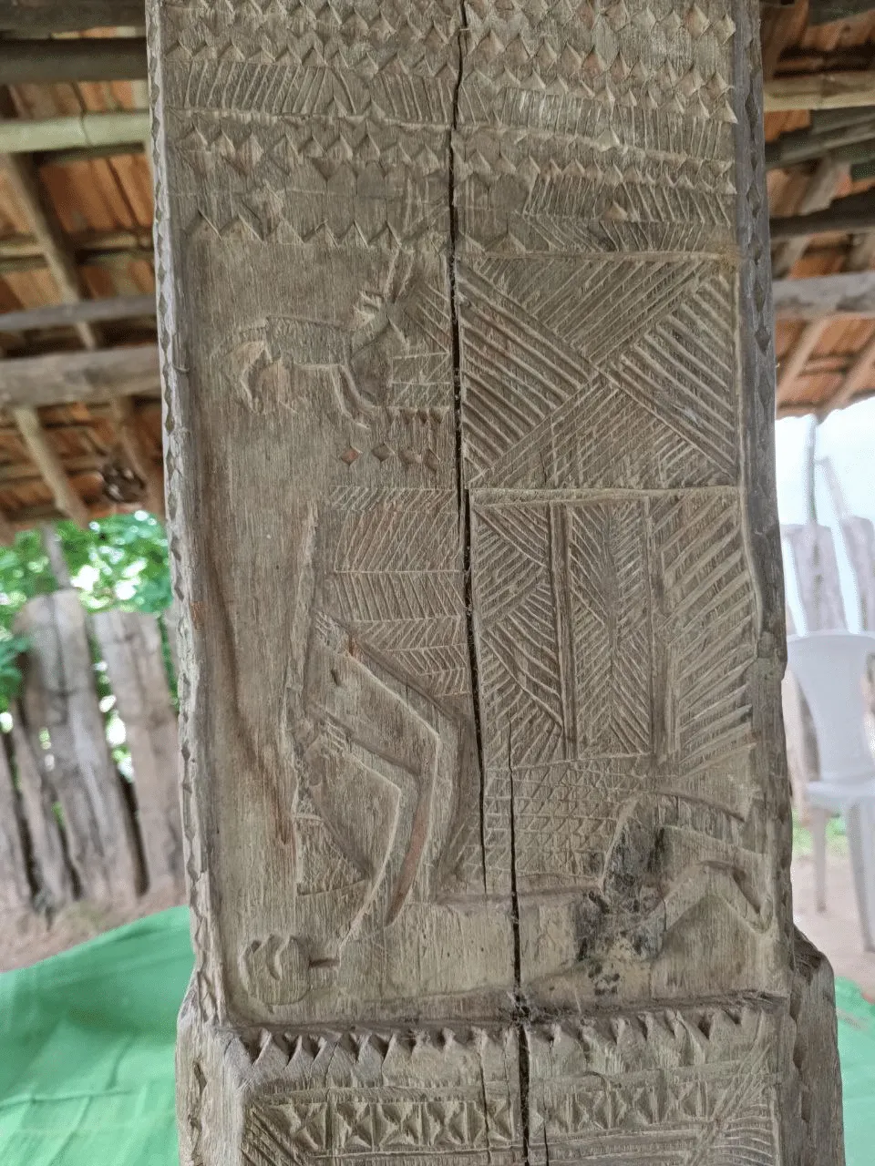 A hunter with a gun, wooden carvings in Gotul, the community centre