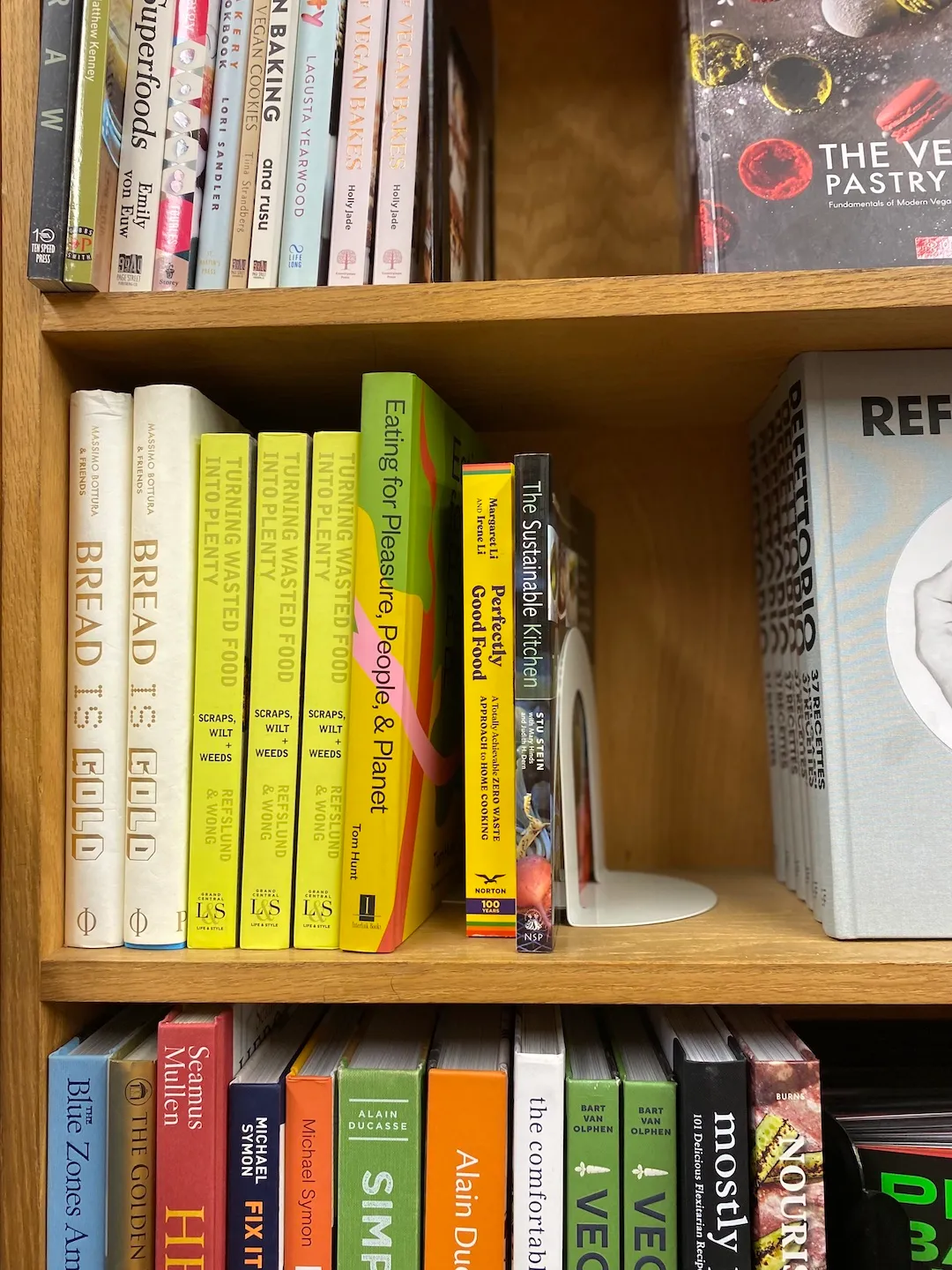 a large bookshelf with books about climate cooking stacked in a corner