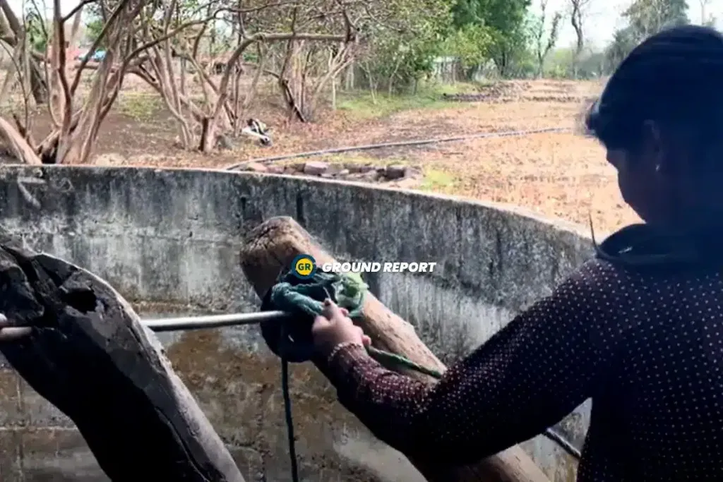 woman fetching water from well india