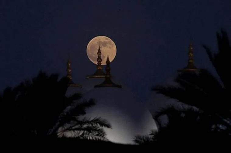 A lunar eclipse of a full Blood Moon rises behind the Sheikh Zayed Grand Mosque in Abu Dhabi, United Arab Emirates (Source REUTERS)