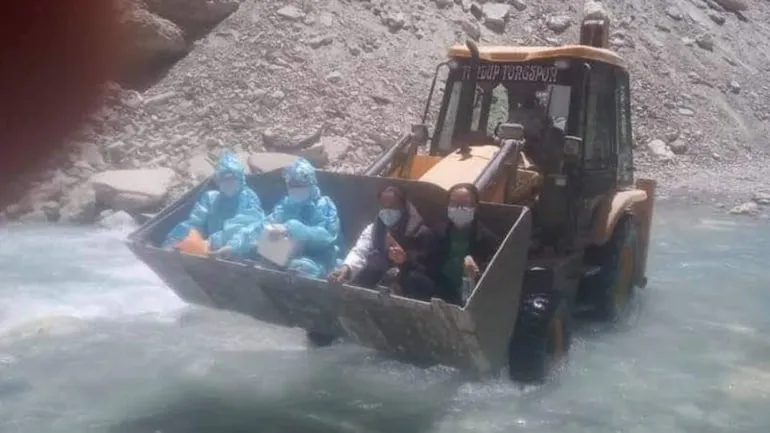 In the image, these COVID-19 warriors can be seen sitting on the loader of an Earth Mover. The internet has been applauding the efforts of these healthcare workers who are crossing the river with the JCB machine.