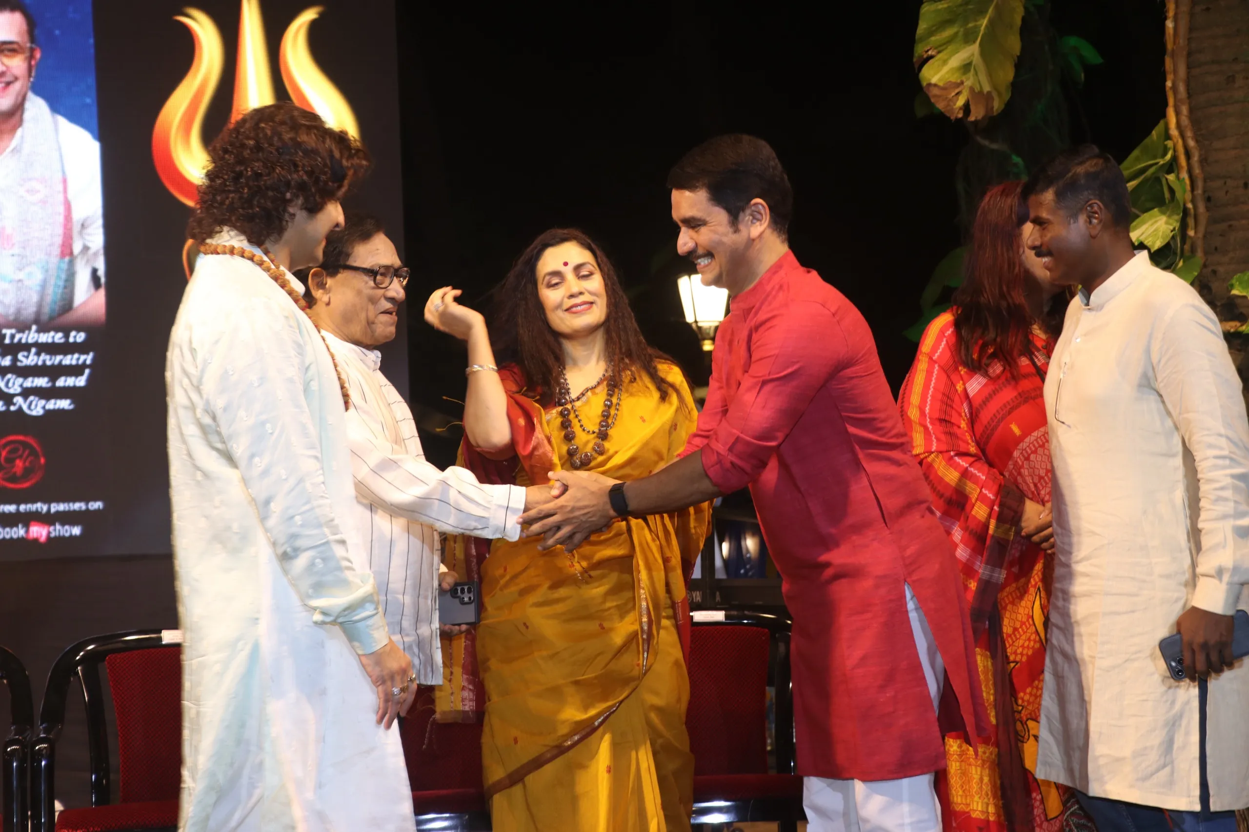 Supercop Vishwas Nangre Patil greets Agam Kumar Nigam while Sonu Nigam and Meenal Nigam look on, at the Adinath Shambhu Maha Shivratri event