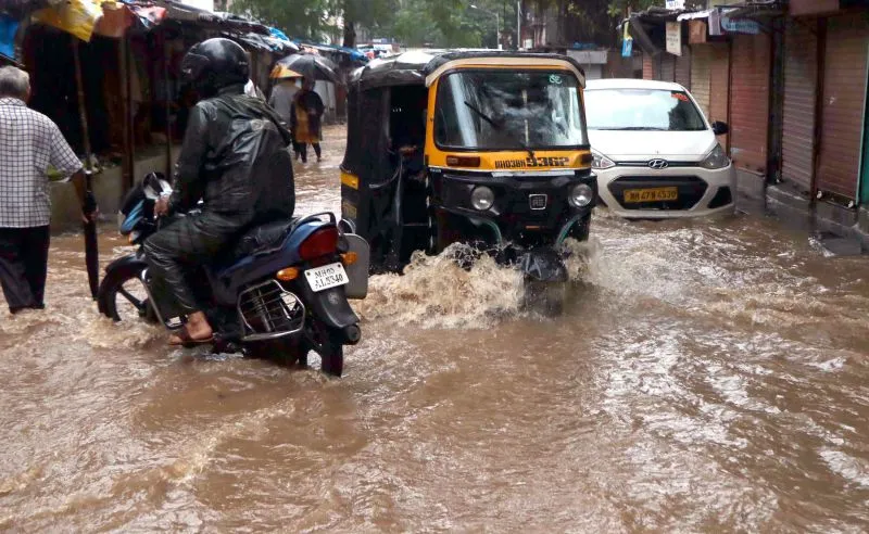 मुंबई में भारी बारिश की वजह से सड़कों पर भरे पानी में फंसी गाड़ियां