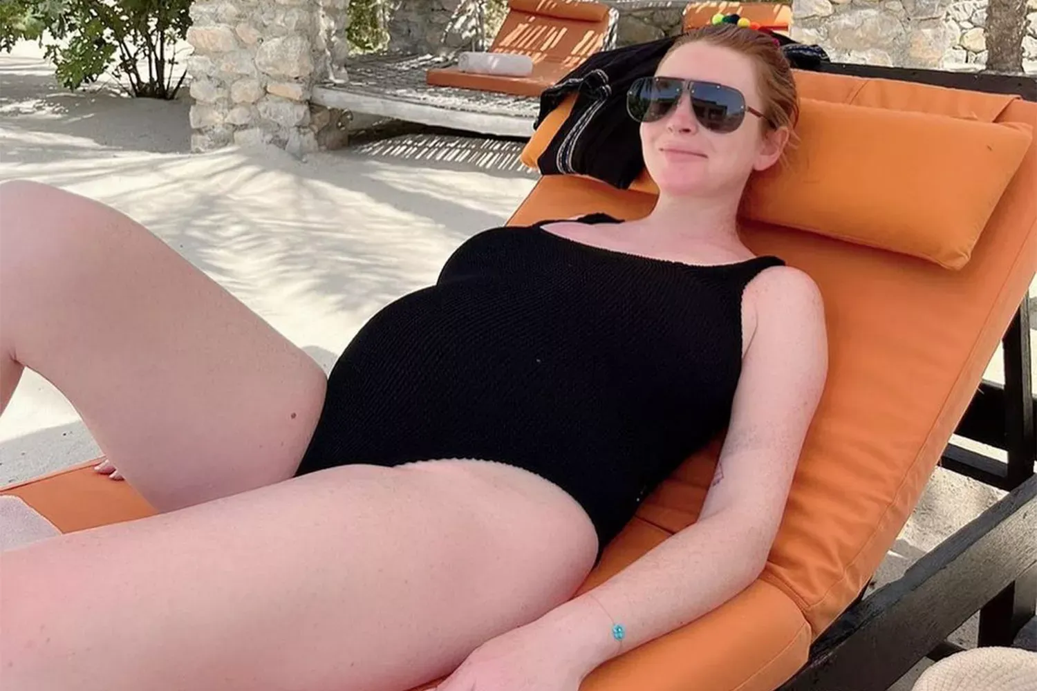 Pregnant Lindsay Lohan Smiles While Lounging with Her Bump in Black Bathing Suit â See the Photo!