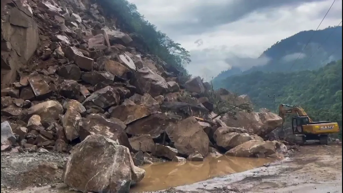 Commuters wait for the clearing of blocked Chandigarh-Manali highway following a landslide triggered by continuous rain in Himachal Pradesh, in Mandi district, Monday, Jun 26