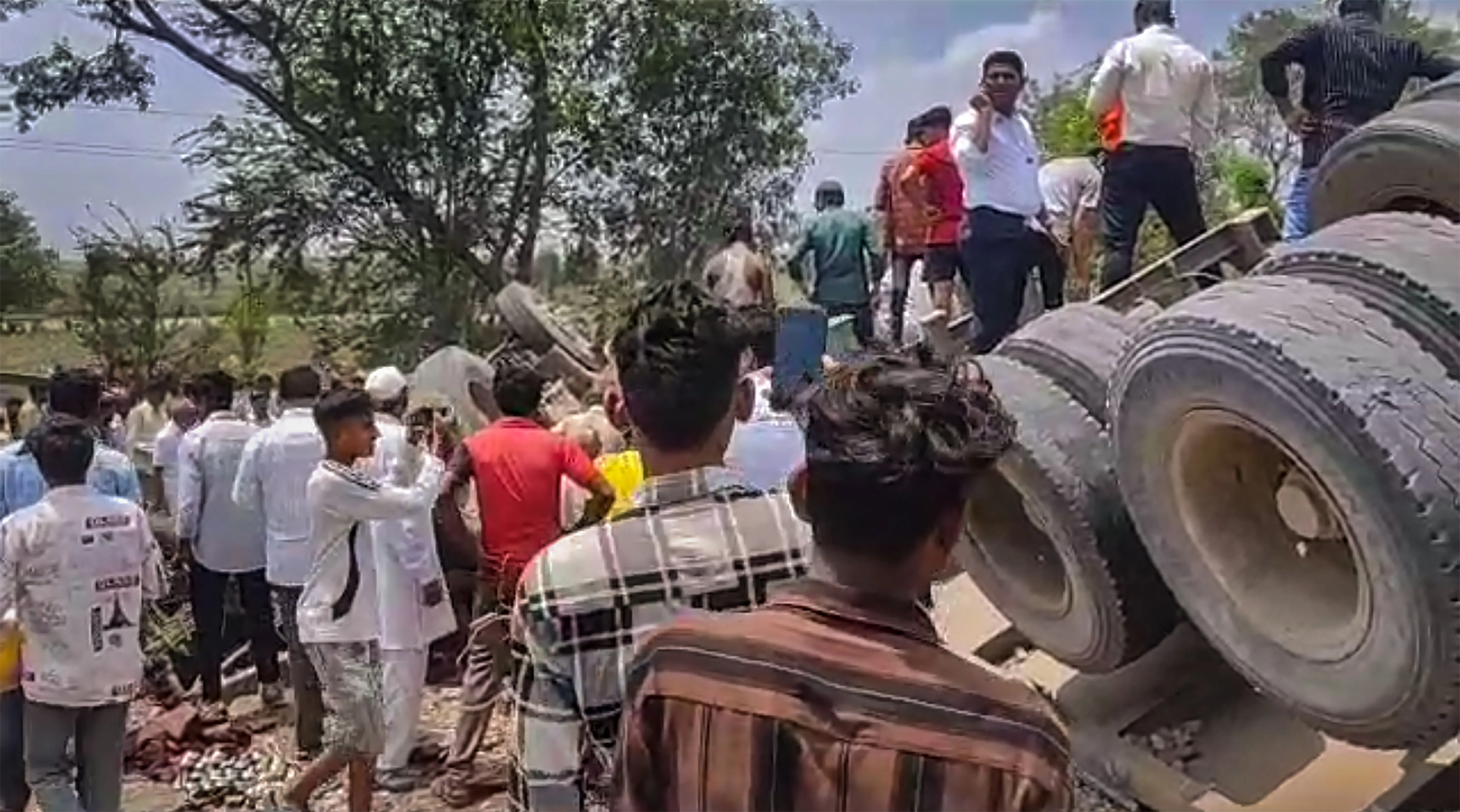 Locals gather at the accident site after a container truck hit four vehicles and then rammed into a hotel on a highway, in Dhule district