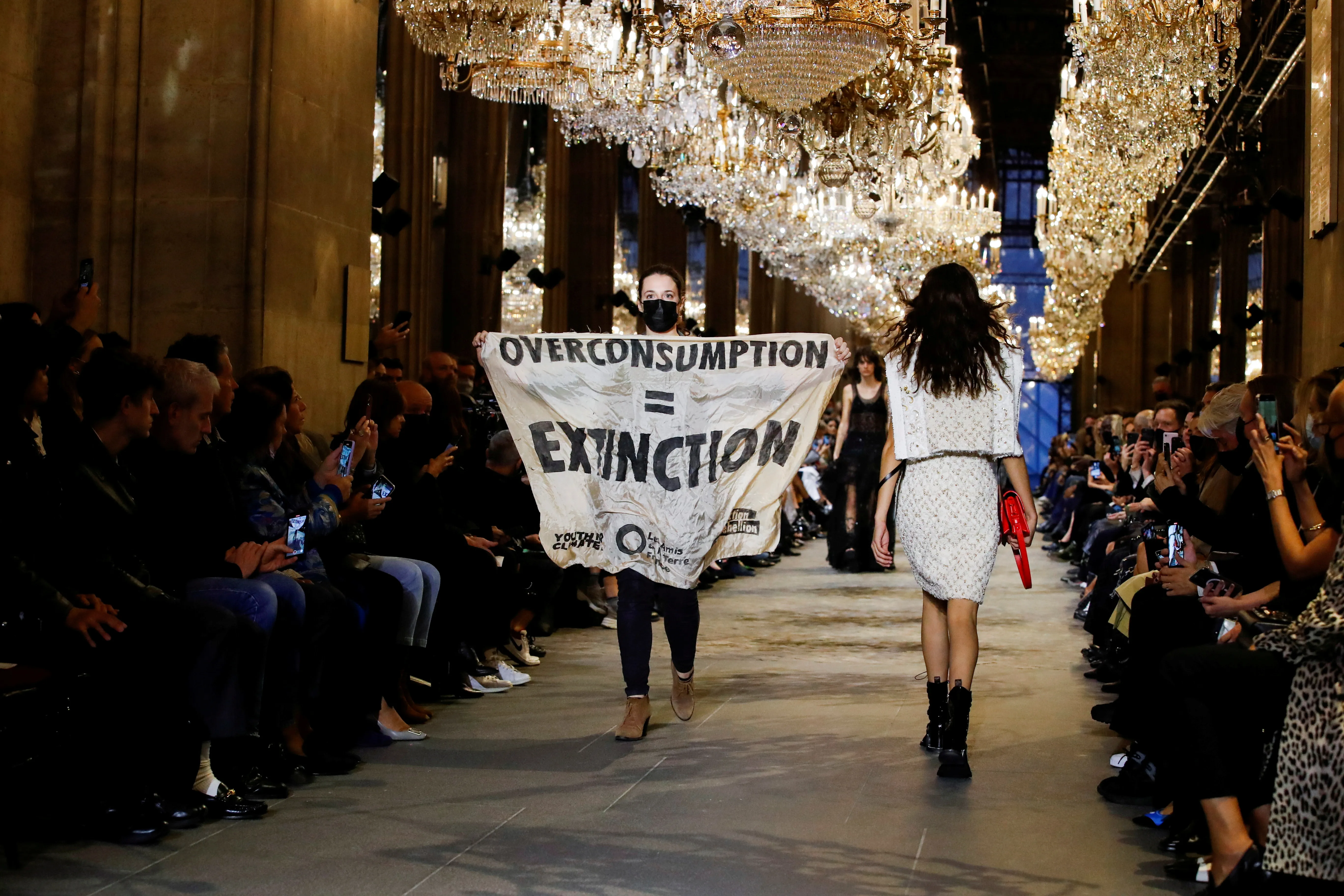 An activist walks on the ramp with a banner that says 