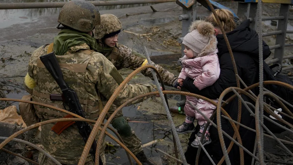 Ukrainian soldier aiding a mother and her child  
