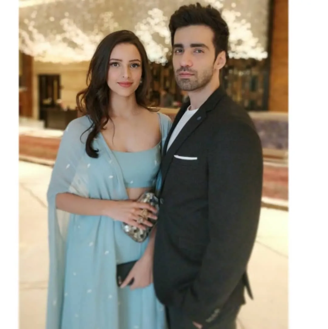 the lead actors of Laila Majnu, Tripti Dimri and Avinash Tiwary. Tripti is wearing a light blue traditional outfit with a matching shawl, holding a small clutch and smiling. Avinash is next to her in a black suit with.jpg  