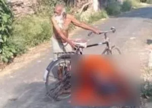 Elderly man carries wife dead body on bicycle after villagers refuse to allow cremation