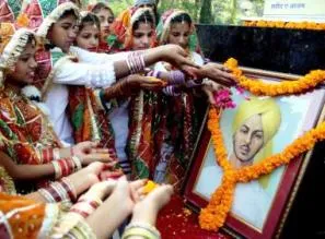 Children pay floral tribute to a portrait of Bhagat Singh  (Photo: IANS)