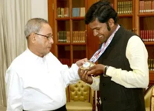 President Pranab Mukherjee taking a close look at the medal Sudarsan Pattnaik won at the sand sculpting World Cup in Atlantic City, USA recently.