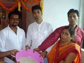 A family in Mumbai offering a bucket of rice (IANS pic)