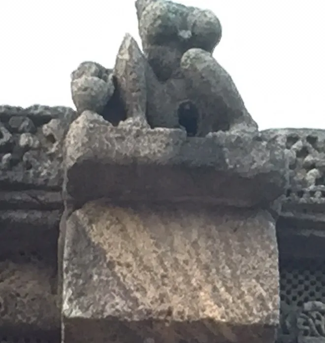 An eroded figurine of a woman; Her vaginal area serves as an opening to drain out rain water from the Nata Mandira