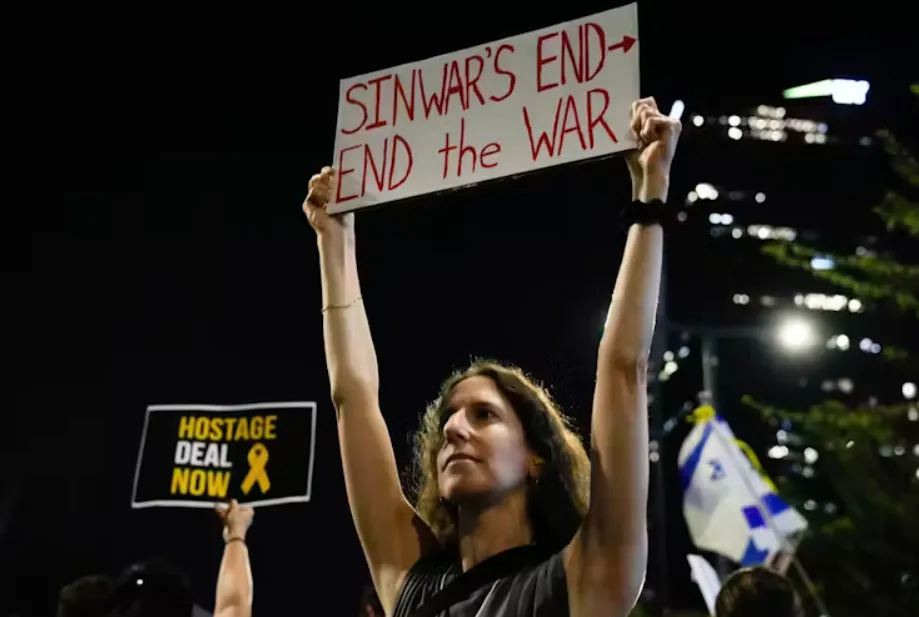 An Israeli demonstrator in Tel Aviv holds a sign calling for a ceasefire deal and the immediate release of hostages held by Hamas. Ariel Schalit/AP