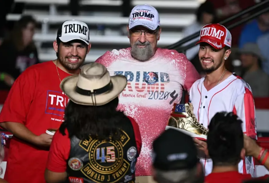 People at a Trump rally in Las Vegas hold a pair of his gold sneakers on Sept. 13, 2024. Patrick T. Fallon/AFP via Getty Images