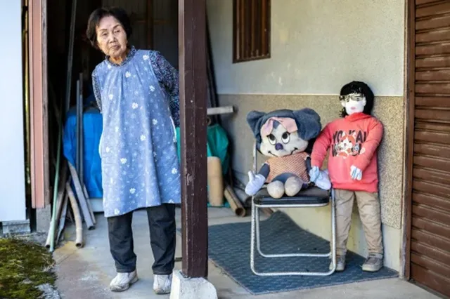 Hisayo Yamazaki standing next to the puppets outside her house in Ichinono.Philip Fong / AFP - Getty Images