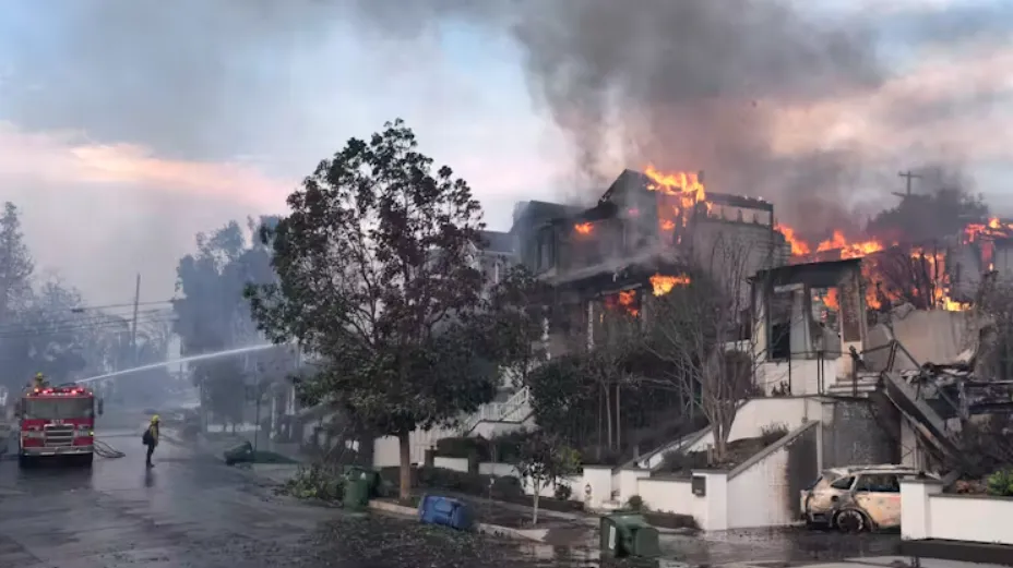 Firefighters work to extinguish burning homes in the Pacific Palisades neighborhood of Los Angeles on Jan. 8, 2025. AP Photo/Damian Dovarganes