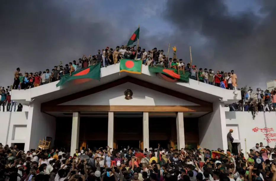 People gather around the former residence of the Bangladeshi prime minister in Dhaka. Stringer/EPA