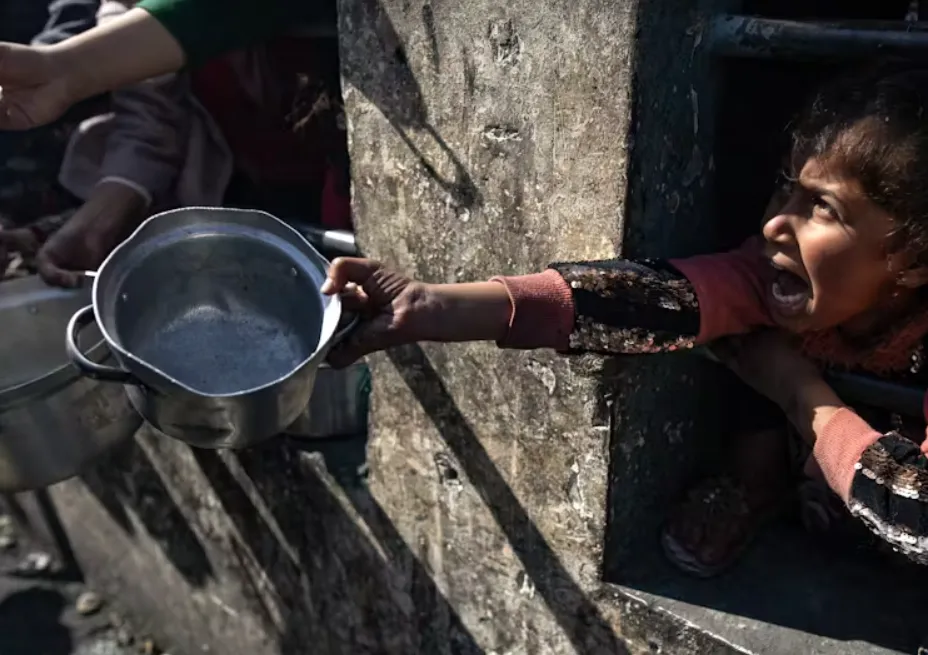 A displaced Palestinian child holds up an empty pot as she waits to receive food aid in the Rafah refugee camp in January. Haitham Imad/EPA