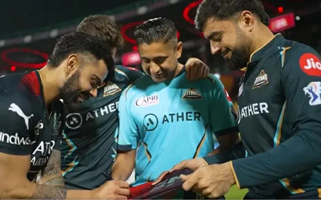 Virat Kohli signing a jersey for Rashid Khan