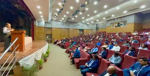 A group of people sitting in a auditoriumDescription automatically generated with low confidence