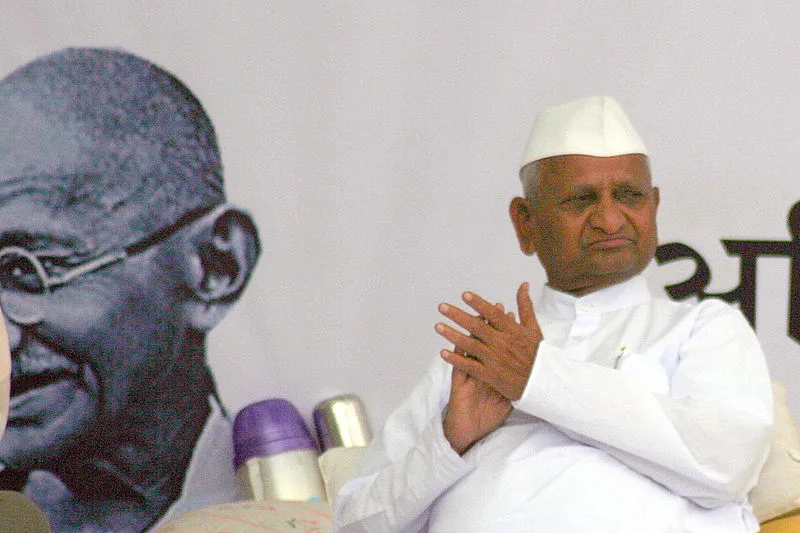 Anna Hazare sitting at a political gathering.