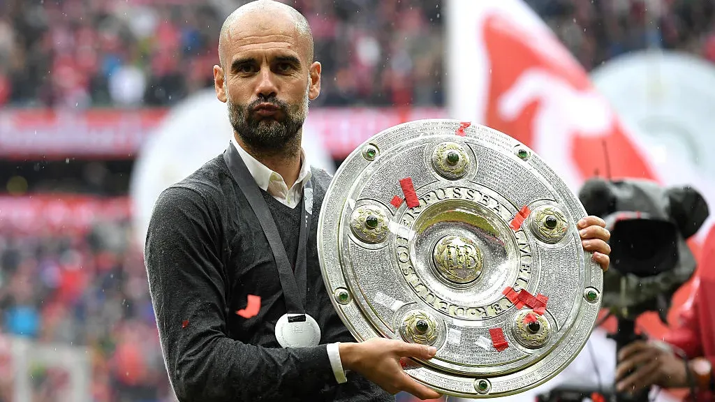 Pep Guardiola holding one of three Bundesliga titles he won with Bayern Munich