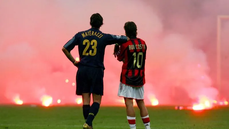 Marco Materazzi and Rui Costa watching the fire at San Siro Stadium in 2005 Milan Derby in UEFA Champions League QFs - sportzpoint.com