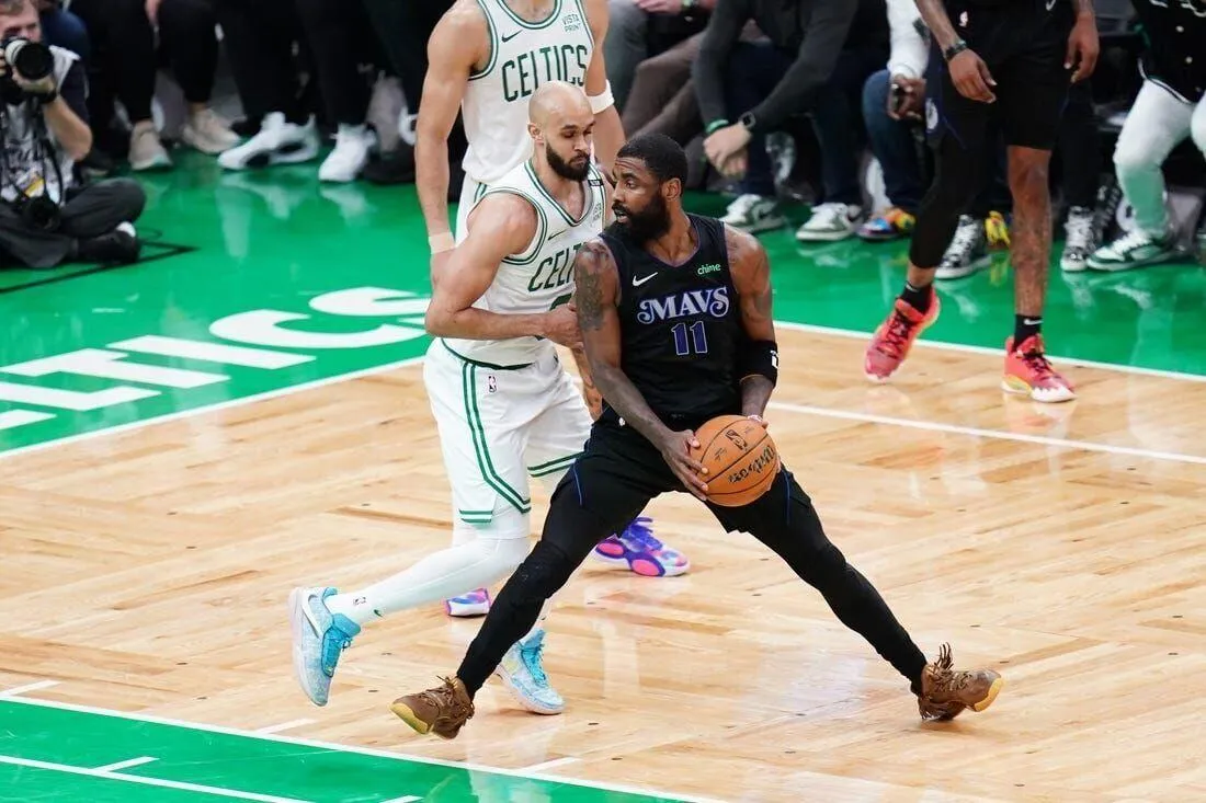 Kyrie Irving (11) controls the ball against Boston Celtics guard Derrick White (9) in the second quarter game one of the 2024 NBA Finals - sportzpoint.com