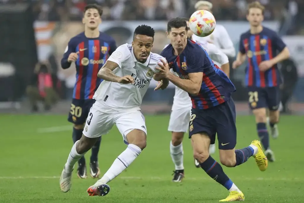 Barcelona vs Real Madrid: Real Madrid defender Eder Militao fights for the ball with Barcelona's Polish forward Robert Lewandowski  | Sportz Point