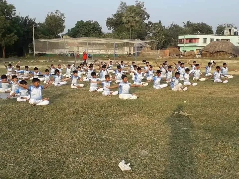 Kids are practising Yoga in the Dream School of Cricket. 