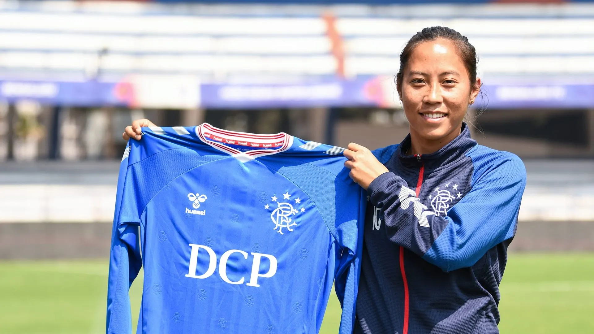 Bala Devi holding the jersey of Rangers FC in 2020.  