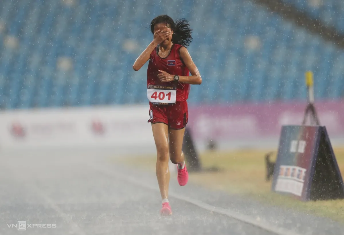 Bou Samnang, of Cambodia, was lauded as an inspiration after completing her race despite a last-place finish during a torrential rainstorm at the Southeast Asian Games.  Image | VN Express