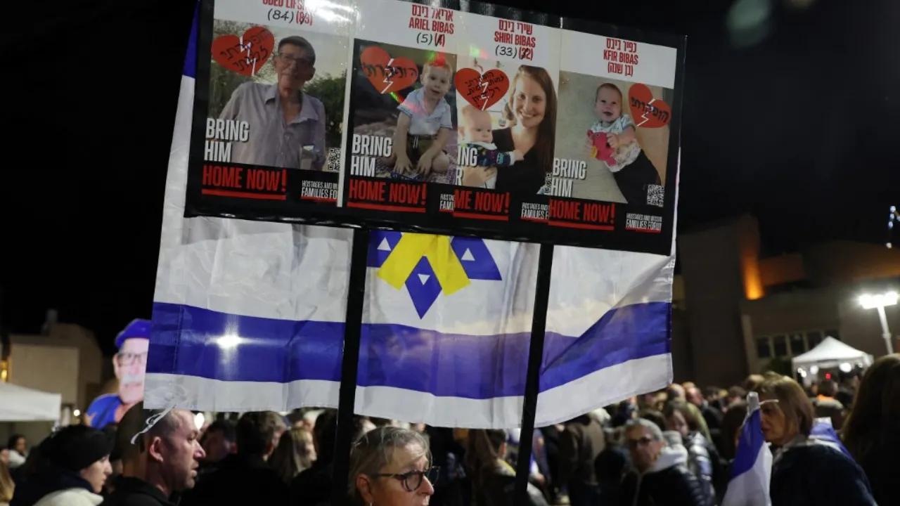  People carry a placard bearing the pictures of Oded Lifshitz and members of the Bibas family, hours after the Palestinian group Hamas handed over the bodies of who it said were those of the four hostages, on February 20, 2025. Photograph: (AFP) 