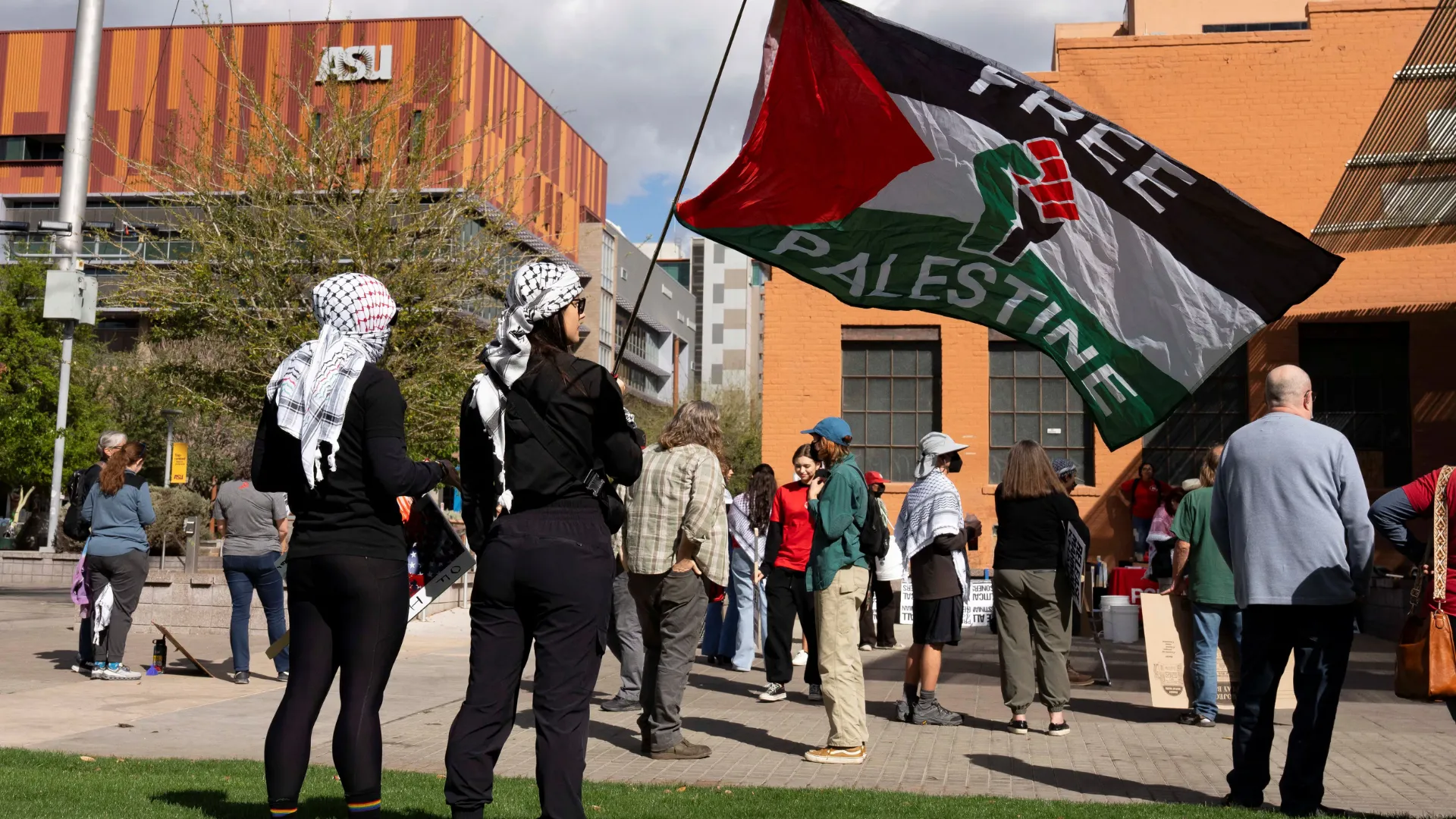  Protesters wearing keffiyehs wave a pro-Palestinian flag during a protest against the ICE detention of Palestinian activist and Columbia University graduate student Mahmoud Khalil, near Arizona State University (ASU) in Phoenix, Arizona, US, March 15, 2025. Photograph: (Reuters) 