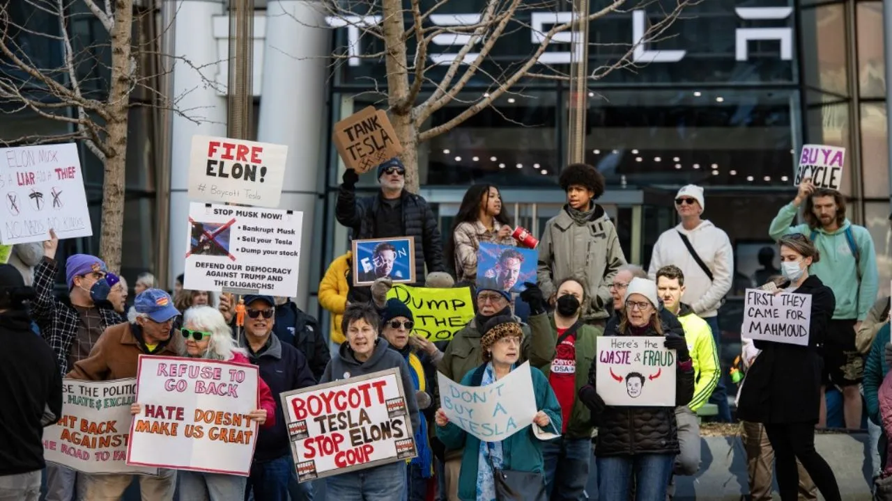  Protesters hold signs and sing chants during a protest against Elon Musk and his Tesla car company outside the Tesla dealership in Boston, Massachusetts on March 15, 2025.  Photograph: (AFP) 